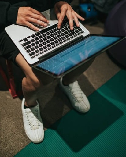 Typing on laptop with feet on yoga mat